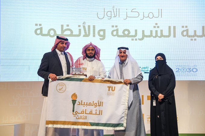 The College of Sharia and Law won the first position in the Third Cultural Olympiad and received its banner